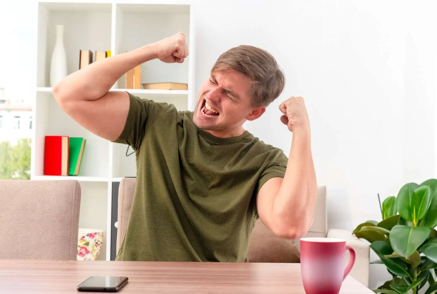 A man stretching his arms out at his desk